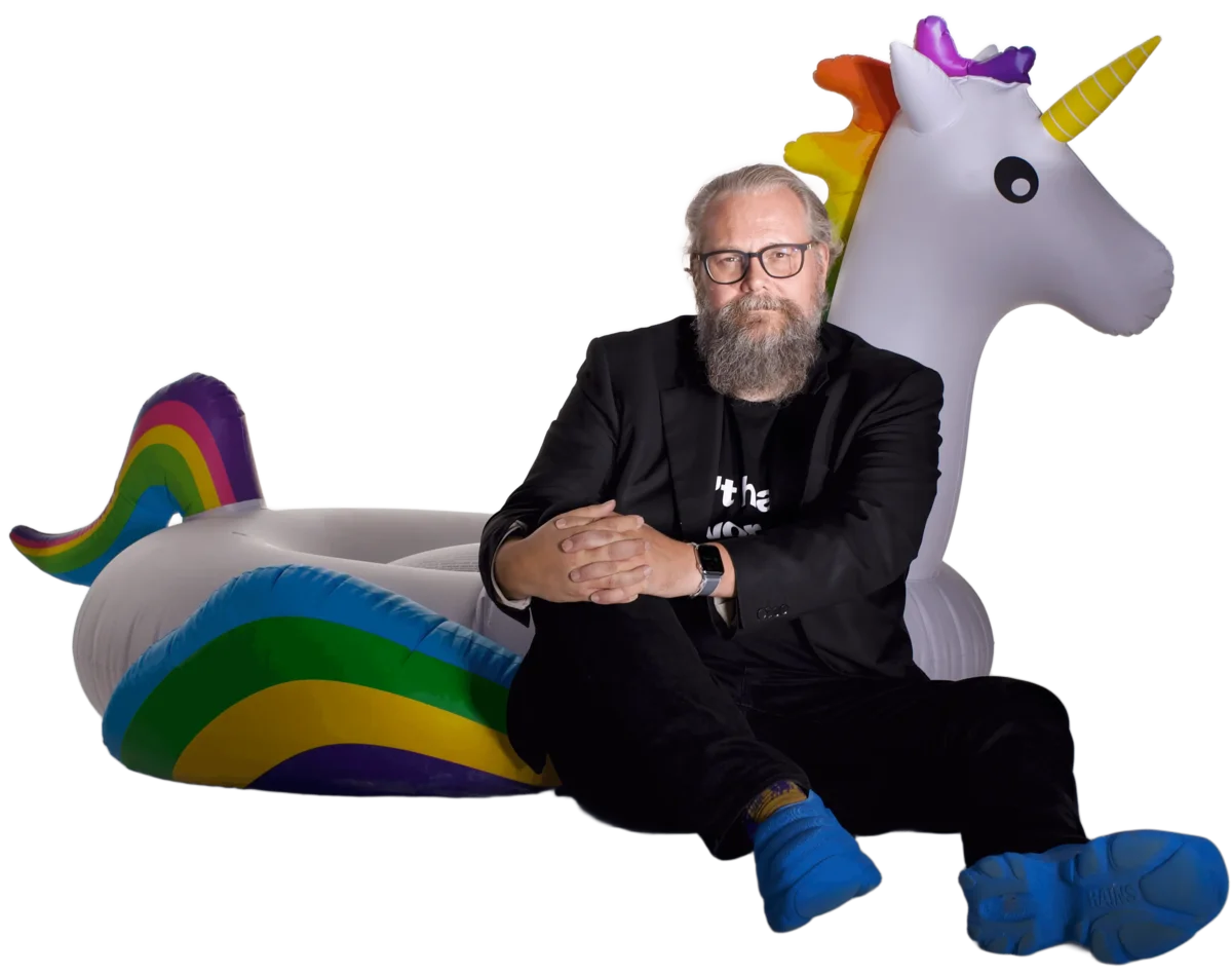Peter Møllebjerg Andersen seated on an inflatable rainbow unicorn float